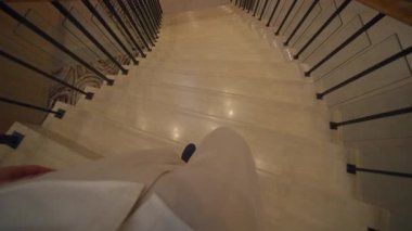 Samimi perspektif, otelin içindeki parlak mermer merdivenlerden inen ayak izlerini yakalıyor.