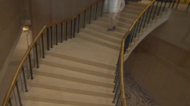 Ziyaretçi merdivenlerde, ziyaretçi mermer merdivenleri süpürüyor. Lüks otel avlusunda dikkatlice.