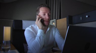 Odaklanmış bir iş adamı, modern ve zarif bir ortamda dizüstü bilgisayarı ustalıkla kullanırken çok önemli bir karar verir.