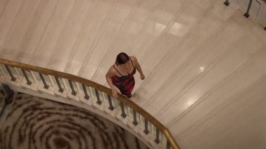 fashionable asian pose, asian influencer showcasing fashionable red dress on marble staircase
