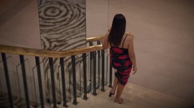 asian woman rehearses runway walk, evening scene of asian woman practicing poised runway descent