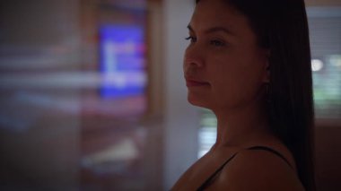 woman quietly examining screen, contemplative woman in dim interior studying screen peacefully