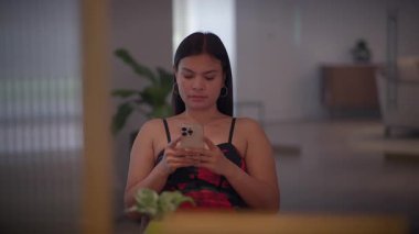 A young woman focused on her smartphone, capturing the essence of modern connectivity in a stylish space.