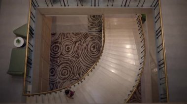 curved stairs and red dress, topdown view of curved staircase with contrasting scale and elegant