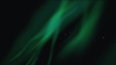 Siyah gökyüzünde süzülen yeşil aurora kurdeleleri dağınık yıldızlarla parıldıyor.,