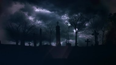 Mor bulutların altında siluetli haçları ve çıplak ağaçları olan fırtınalı mezarlık, sürüklenen sis