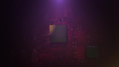 Mor ışıklı, merkezi çipli, spot ışıkları altında, teknisyen yakın çekimde izler görülüyor.