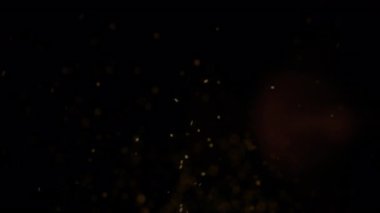 Yüzen siyah arka plan altın tozu. Lüks tanıtım için zarif bir parıltı.