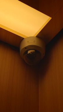 Güvenlik kubbesi kamerası sıcak ışıklı tavan köşesine monte edilmiş, kapalı mekan izleme açısı, parlak mercek, koruyucu