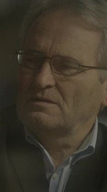 Düşünceli, yaşlı, gözlüklü, duygusal bir ana kapılmış, derin düşüncelere dalmış bir adam..