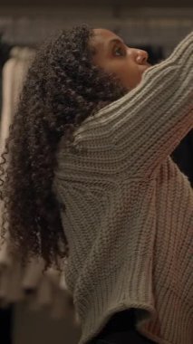 Alışverişci şık bir perakende ortamında canlı ve güzel desenli bir çiçek eşyasını yakından inceler.