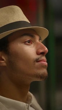 Şık bir şapkası olan genç bir adam heyecan verici bir olay sırasında spontane ve samimi bir şekilde yakalanır.