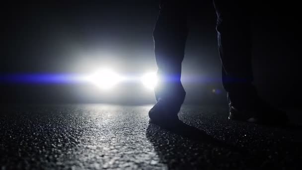 Personne debout devant les feux de voiture — Video