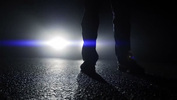 Persona de pie delante de las luces del coche — Vídeos de Stock