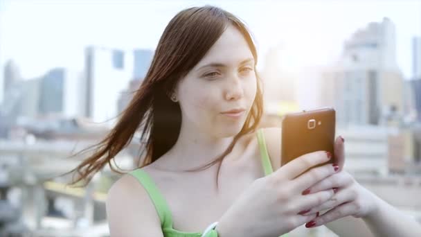 Молодая женщина использует смартфон на открытом воздухе — стоковое видео
