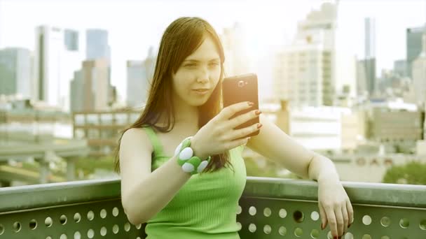 Mujer joven usando el teléfono inteligente al aire libre — Vídeos de Stock