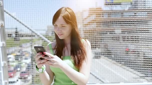 Jonge vrouw met behulp van slimme telefoon buitenshuis — Stockvideo