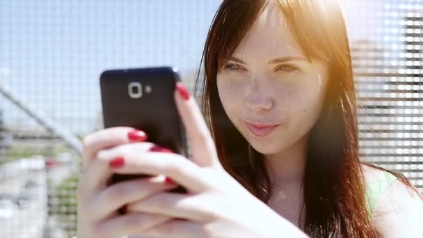 Jeune femme utilisant un téléphone intelligent à l'extérieur — Video