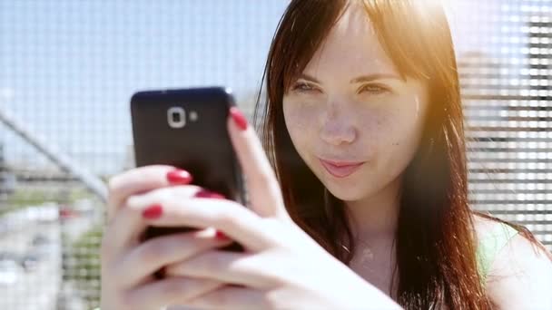 Jovem mulher usando telefone inteligente ao ar livre — Vídeo de Stock