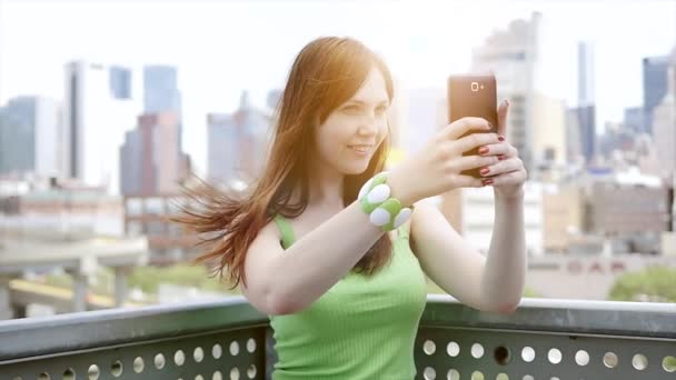 Молодая женщина использует смартфон на открытом воздухе — стоковое видео