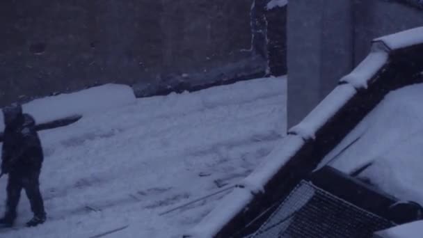 Gente paleando nieve en la azotea — Vídeo de stock