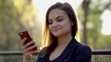 Dışarıda akıllı telefon kullanan bir kadın.