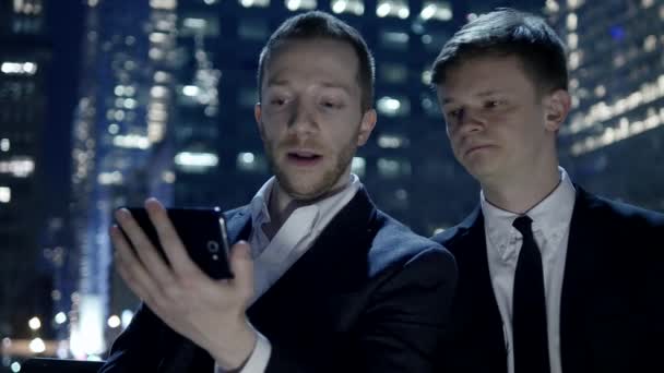 Businessmen looking at smart phone — Stock Video