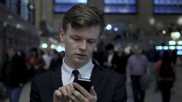 Бизнесмен пишет смс на смартфоне — стоковое видео