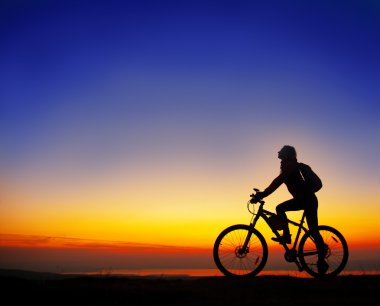 Girl with a bicycle watching the sunset clipart