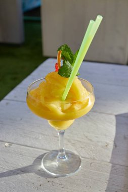 Güneşli bir günde beyaz arka planda Mango Daiquiri kokteyli