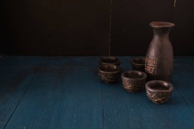 Mavi ahşap masanın üzerine koyu arkaplan şeklinde saki.