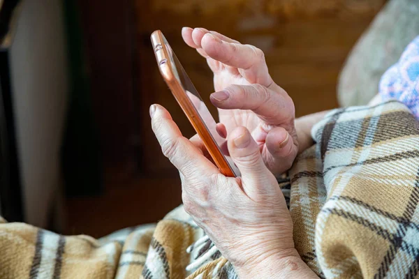 Old woman hands with a mobile phone calling for delivery or emergency services