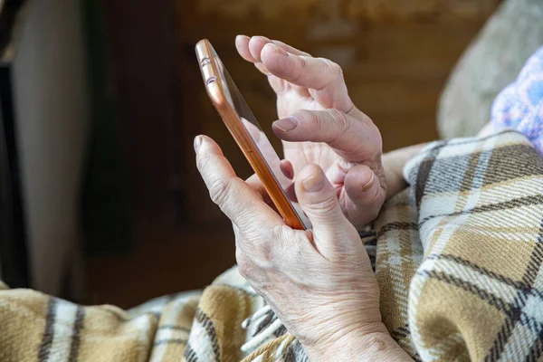 Las Manos Una Anciana Con Teléfono Móvil Llamando Para Entrega Imagen de stock