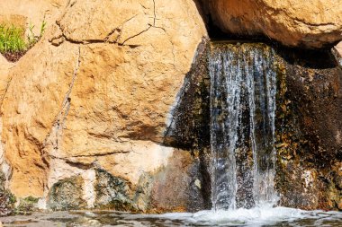 Sarı kayalıklarda kopya alanı olan küçük bir şelale.