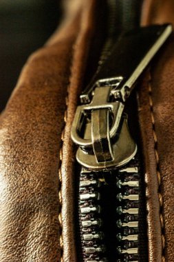 Deri bir ürünün üzerine kilitlenmiş fermuar bağlayıcının yakın çekimi.