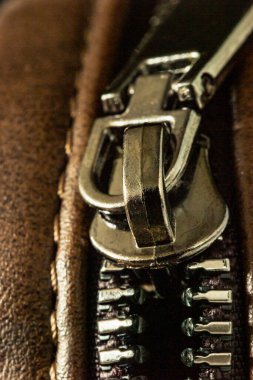 Deri bir ürünün üzerine kilitlenmiş fermuar bağlayıcının yakın çekimi.