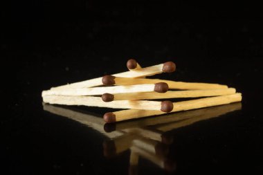 Tahta kibritler kahverengi ve siyah arkaplanda sülfür başları var.