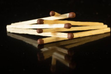 Tahta kibritler kahverengi ve siyah arkaplanda sülfür başları var.