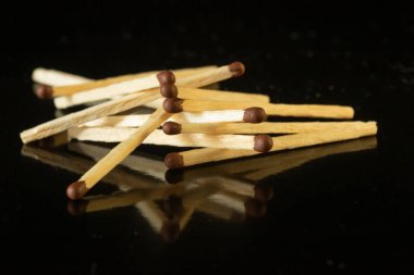 Tahta kibritler kahverengi ve siyah arkaplanda sülfür başları var.