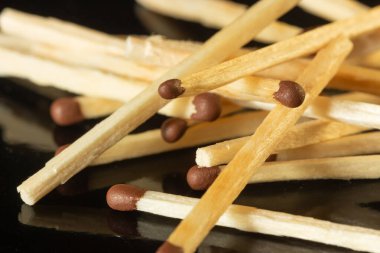 Tahta kibritler kahverengi ve siyah arkaplanda sülfür başları var.