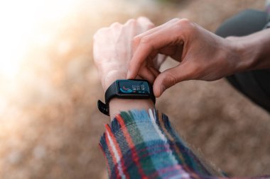 Yürüyüşçü kalp atış hızı monitörünü, akıllı kontrol performansını ya da GPS 'i kullanıyor. Gezgin kronometreye bakıyor. İzleme etkinliği teknolojisi.