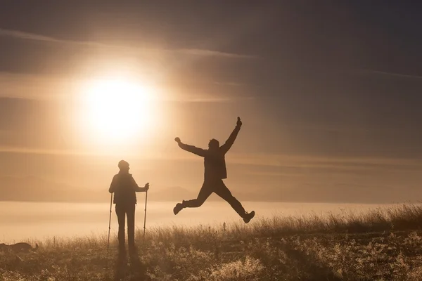 Silhouette aktiva par i kärlek med Trekking pol i på morgondimman — Stockfoto