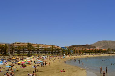 Kumsalda güneşlenen turistler
