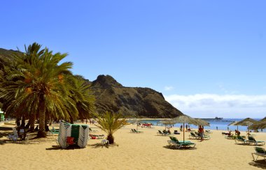 Kumsalda güneşlenen turistler