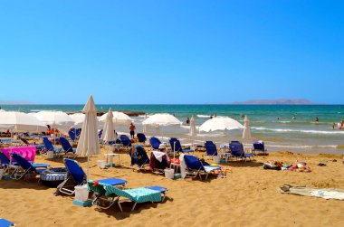 Gouves, Kıbrıs, Yunanistan - 3 Haziran 2019: Girit 'teki Gouves plajında güneşlenen turistler Yunan adalarının en büyük ve en kalabalık adaları.