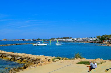 Paphos, Kıbrıs, Yunanistan - 5 Haziran 2018: Paphos limanında dinlenen turistler Kıbrıs 'ta popüler bir turizm beldesi işletiyorlar