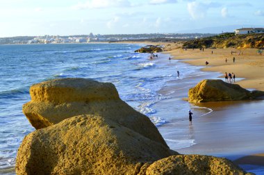 Praia da Gale Plajı 'nda akşam güneşinden keyif alan turistler