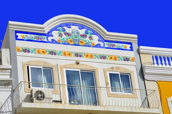 Blommig tileson fram sidan av ett hus med en balkong i Loule — Stockfoto