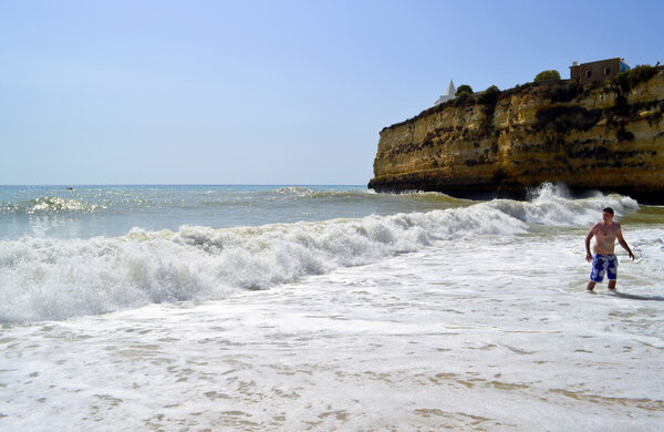 Турист, наслаждающийся морем на пляже Senhora Da Rocha в Португалии
