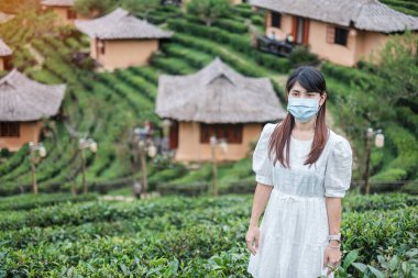 Cerrahi maske takan mutlu turist kadın güzel çay bahçesinin, Coronavirus hastalığının (Covid-19) tadını çıkarıyor. Yeni Normal, seyahat, tatil ve tatil kavramı